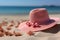 Beach vacation A pink straw hat rests on sandy shores