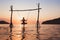 Beach vacation on the sea at sunset, holidays on paradise tropical island, silhouette of woman on swing