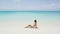 Beach vacation in summer - bikini girl sunbathing on travel holidays in paradise