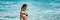Beach vacation summer travel lifestyle banner panorama. Asian woman relaxing in sun holidays . Bikini model swimming in