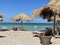 Beach in Vama Veche resort, with wooden sunbeds and reed umbrellas