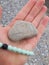 Beach vibes. Hand holding weathered stone with cool layers