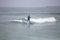 Beach view with professional Standup Paddleboarding doing extreme maneuvers in sea with waves