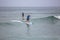 Beach view with professional Standup Paddleboarding doing extreme maneuvers in sea with waves