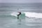 Beach view with professional surfers doing extreme maneuvers in sea with waves