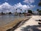 Beach view on shoreline with houses palm trees and swimmers