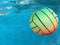 Beach volleyball ball floating in swimming pool. Copy space