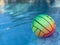 Beach volleyball ball floating in swimming pool. Copy space