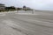 Beach volleyball net on a deserted recently raked beach sand court near thee ocean on an overcast day