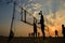 Beach volleyball silhouette at sunset , blurred