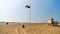 The beach of vrouwenpolder with a black and white checkered flag waving in the wind, water sports allowed sign, touristic coastal