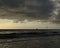 Beach with waves and cloudy sky at dawn