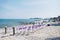 Beach wedding venue settings with white chiavari chairs decorate with purple organza sash at seaside