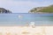 Beach with a white fishing chair and a tied fishing boat at Porto Koufo harbor