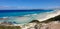 A beach of white sands meets an ocean of cascading blues and dense Australian bushes