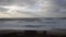 Beach in winter with nobody, waves and cloudy sky in normal speed