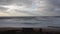 Beach in winter with nobody, waves and cloudy sky in slow speed