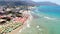 Beach world famous as a surfer`s paradise. Deck chairs. Ocean surf and waves. Stone cliffs. Aerial view. Greece, Crete