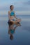 Beach yoga practice in Bali. Lotus pose. Padmasana. Hands in gyan mudra. Meditation and concentration. Zen life. Relaxation of