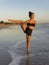 Beach yoga practice. Svarga Dvijasana, Paradise Bird Pose. Strong legs. Standing balancing asana. Healthy lifestyle. Fit body.