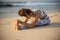 Beach yoga. Young woman practicing Paschimottanasana, Seated Forward Bend Pose. Flexible body. Stretching exercise. Healthy spine