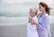 Beach, young woman and her senior mother embrace or look at horizon outdoors. Mock up, free and hugging elderly woman