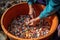 beachcomber sifting through bucket of colorful shells and stones