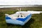 A beached row boat on green grassy marsh land in Orford, Suffolk