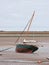 Beached sail boat at low tide