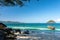 Beaches of small islands, clear water The turquoise has trees, large stones and a boat floating in the water