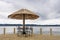 Beachfront terrace with chairs, table and straw parasol, sea and