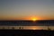 Beachgoers watch sunset  near Crystal Pier in San Diego
