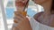 At a beachside cafe, a woman drinks orange juice, symbolizing summer holidays and coastal relaxation