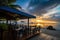 beachside eatery with outdoor seating and stunning sunset view