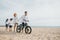 Beachside family fun , Parents push their bicycles along the sand creating a