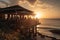 beachside restaurant, with the sun setting beyond the horizon and patrons enjoying sunset cocktails