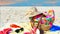 Beachwear  handbag women  accessories summer beachwear hat sneakers red dress sunglasses and cup of coffee on yellow towel on sand