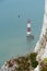 Beachy head lighthouse at the edge of white chalk cliff. Safety warning in the ocean