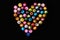 Beads, colorful beads on a black background, arranged a heart shape.