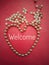 Beads or perls with text on red background,lined a heart