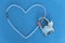 Beads of rock crystal laid out in the shape of a heart on a blue background. Nearby is a lockable lock in the form of a