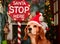 Beagle cute dog with Santa`s red hat and Stop sign lighted. Christmas