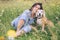 Beagle dog portrait with its woman owner looking at camera while sitting in high green grass. Female hugging her pet friend and