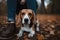 Beagle dog sitting on the ground in the autumn forest with his owner AI Generated
