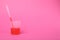Beaker with liquid and stirring rod on bright pink background, space for text. Kids chemical experiment toy