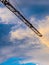 Beam of crane under clouds in blue sky