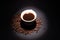 Beam of light on protein coffee bucket with a drink in coffee beans on a dark background