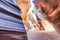 Beam of sand is flowing off the rocks in the interior of the narrow walls of the winding Antelope Canyon, Arizona