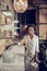 Beaming Afro-American bartender holding on bar shelves filled alcohol