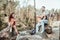 Beaming bearded man singing romantic song for his woman sitting near the canyon